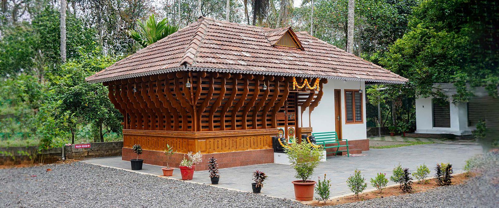 The carved wooden Kerala-style cottage in the garden