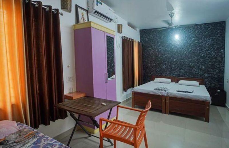 A room with a writing table and a second bed