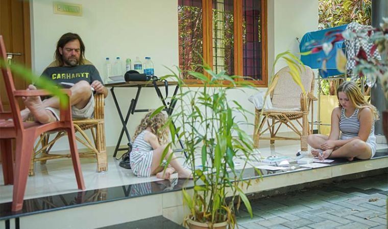 Guests reading on the verandah among potted plants